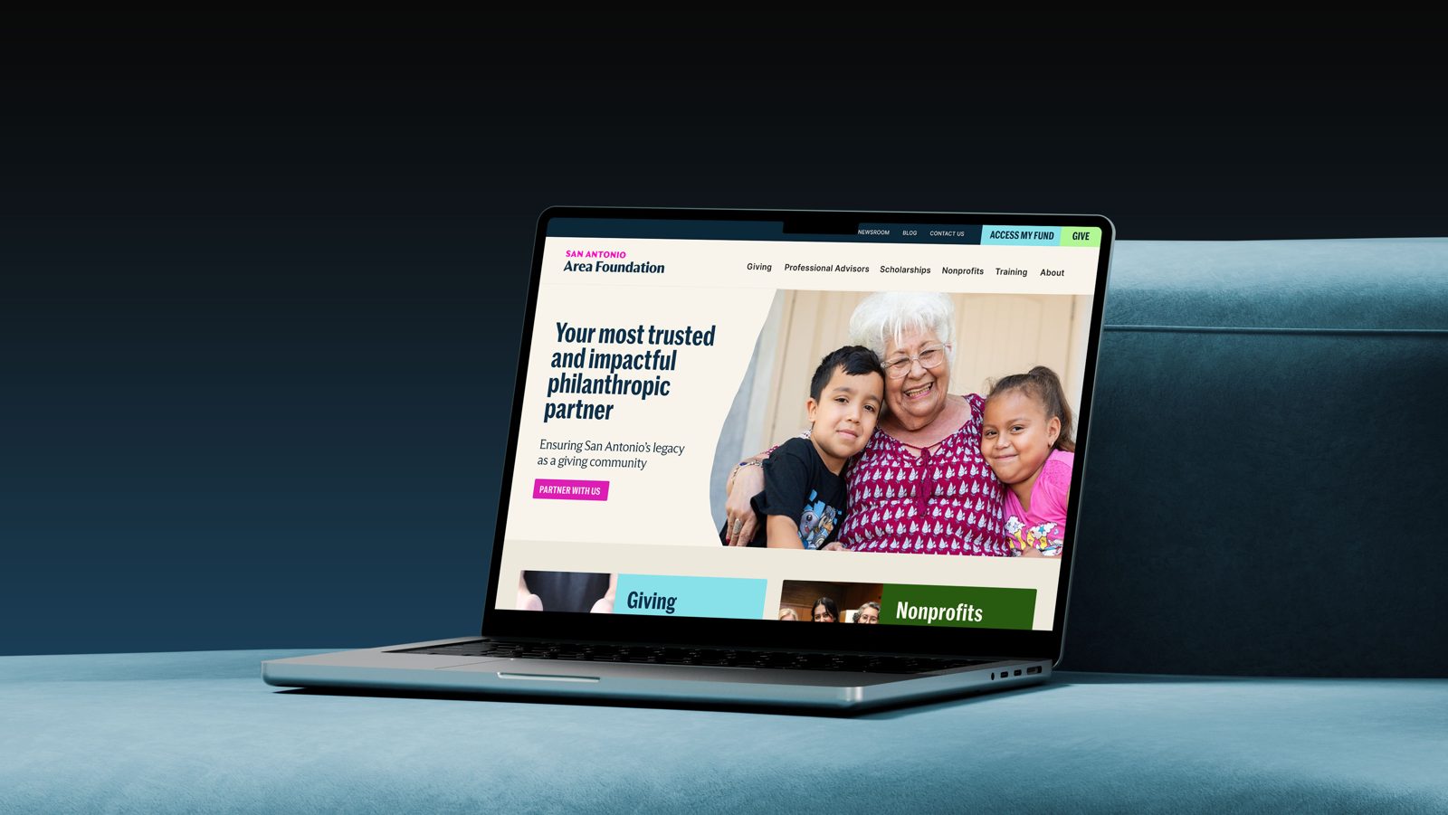A laptop showing the website with a photograph of a grandmother and children